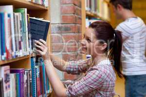 Pretty young woman looking for a book