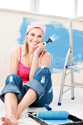 Cheerful woman painting a room