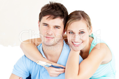 Portrait of a young enamored couple painting their new room