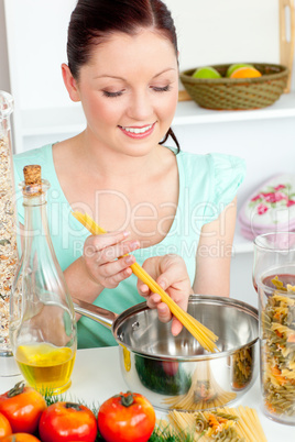 Charming woman cooking sphaghetti in the kitchen