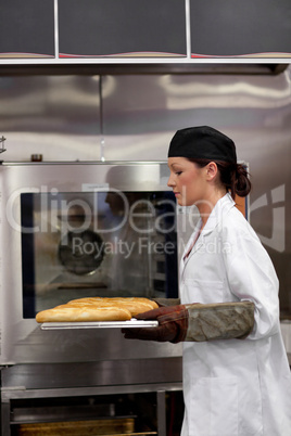 Charming young baker with baguettes