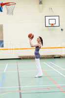 Concentrated woman practicing basketball
