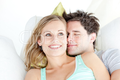 Portrait of a hugging couple sitting on a sofa in the living-roo