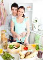 Enamored young couple cutting vegetables in the kitchen