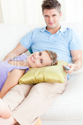 Affectionate couple watching television on the sofa in the livin