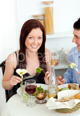 Smiling young couple dining in the kitchen