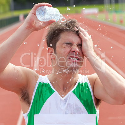 Young sprinter spraying water on his head