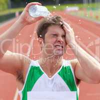 Young sprinter spraying water on his head