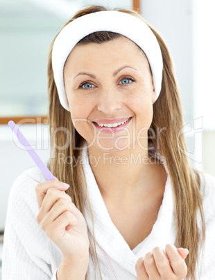 Positive woman filling her nails in the bathroom