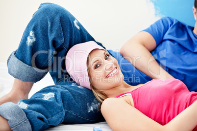 Delighted couple relaxing after painting a room