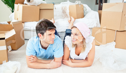Young couple lying on the floor after unpacking boxes