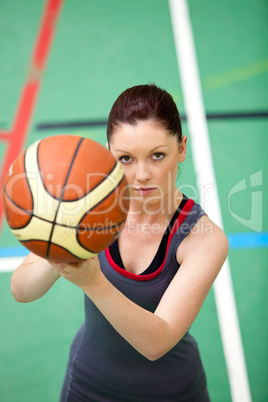 Portrait of a concentrated young woman playing basket-ball