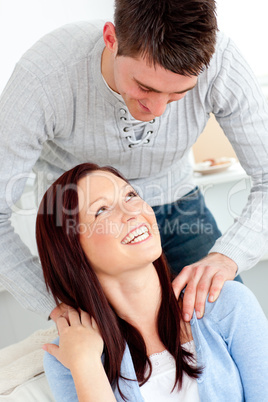 Lovely boyfriend massaging his girlfriend's shoulders on the sof