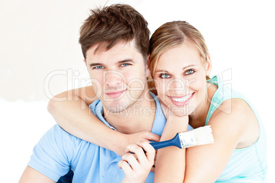 Smiling caucasian couple painting a room