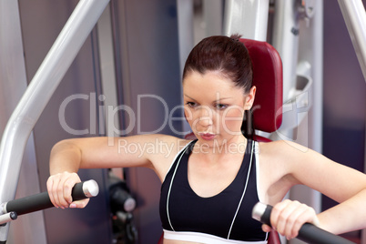 Serious athletic woman using a bench press