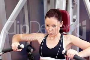 Serious athletic woman using a bench press