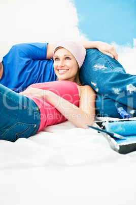 Positive couple relaxing after painting a room