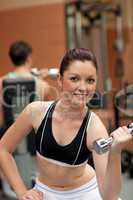 Portrait of an attractive woman working out with dumbbells