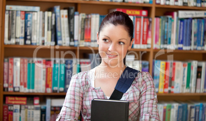 Joyful young caucasian woman holding a book