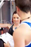 Assertive athletic woman using a bench press with her coach