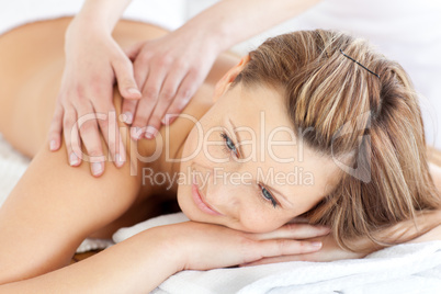 Positive young woman having a back massage in a spa center