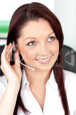 Serious young businesswoman with earpiece in a call center