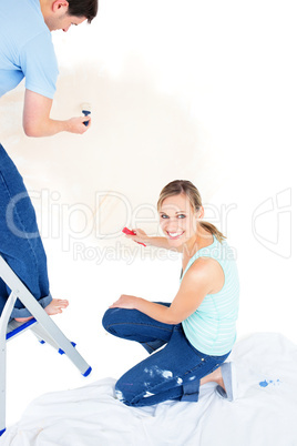 Serious caucasian couple painting a room