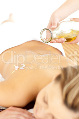 Glad young woman enjoying a back massage with oil