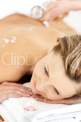 Pretty young woman enjoying a back massage with oil