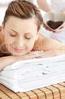 Smiling caucasian woman lying on a massage table in a spa center