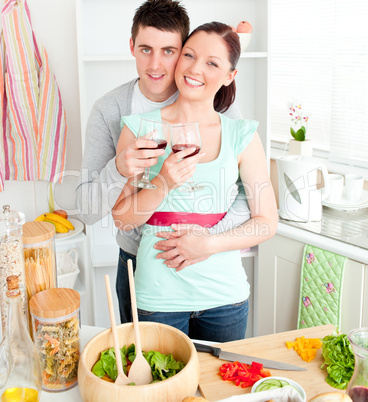 Affectionate couple drinking wine in the kitchen