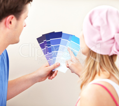 Concentrated couple choosing color for a room in their new house