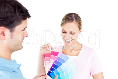 Delighted couple choosing color for a room