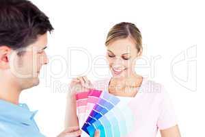 Delighted couple choosing color for a room