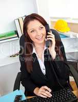 Ambitious businesswoman talking on phone using her computer