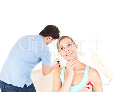 Joyful young couple painting a room