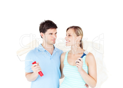 Lovely young couple painting a room