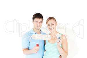 Charming caucasian couple painting a room