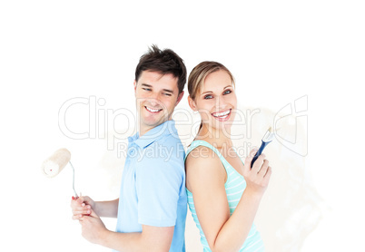 Bright young couple painting a room