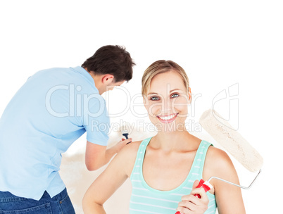 Bright caucasian couple painting a room