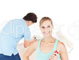 Bright caucasian couple painting a room