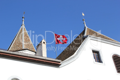 Swiss flag floating on the roof of Nyon castle, Switzerland