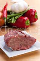 rohes Fleisch und Gemüse auf einem Holztisch