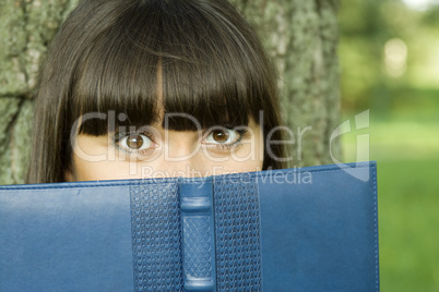 Female in a park with a notebook