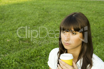 Beautiful girl in the park with coffee