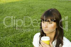 Beautiful girl in the park with coffee