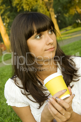 Beautiful girl in the park with coffee