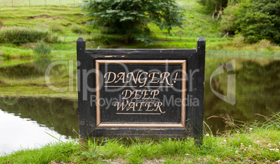 Old warning sign by lake