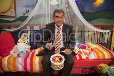 Mature man wearing suit playing toy drum