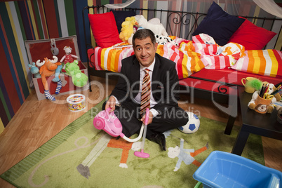 Mature man playing in children;s bedroom